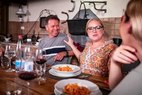 group of people enjoying pasta in small, local italian restaurant