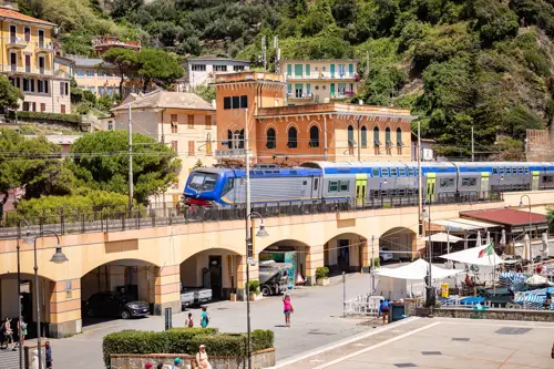 1. A train crosses a bridge in a bustling town, showcasing the blend of urban life and transportation.