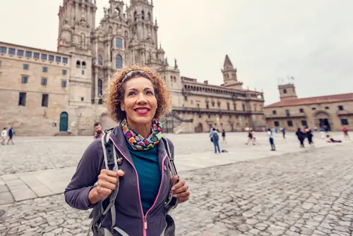 Woman stands in front of Cathedral of Santiago de Compostela