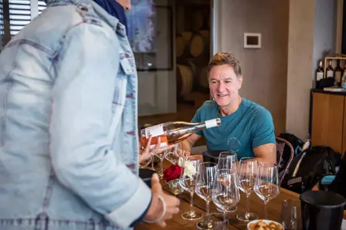 waitress pouring wine for man in restaurant