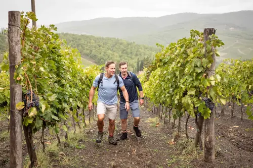 two men hiking through vineyard in Italy