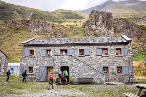 Traditional mountain hut on the TMB with 5 people outside